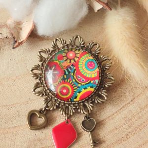 Broche cabochon et ses breloques